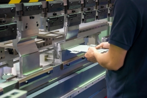 The operation of hydraulic bending machine with technician. The sheet metal manufacturing process by press brake bending machine with technician operator.